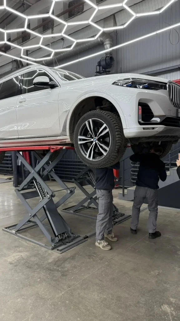 Эксперты АвтоВердикт осматривают днище автомобиля на подъёмнике